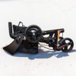 dubbel opgeklapte zwarte lichtgewicht rollator op het stand